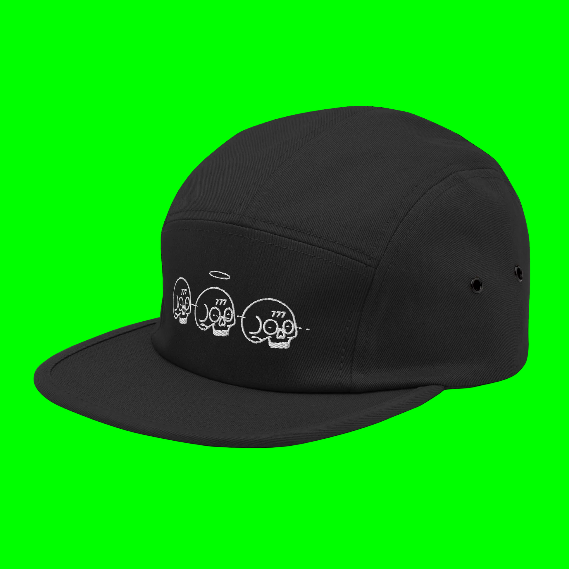 A black 5-panel camper with a flat brim, featuring three white embroidered skulls on the front panel. The skulls are detailed with small white accents like halos and the number '777'.