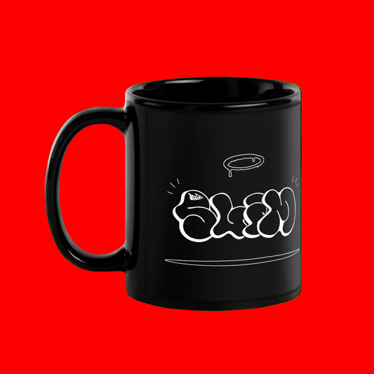 A glossy black ceramic mug with a white graffiti-style graphic spelling 'SLIM' on the side, shown against a solid bright green background.